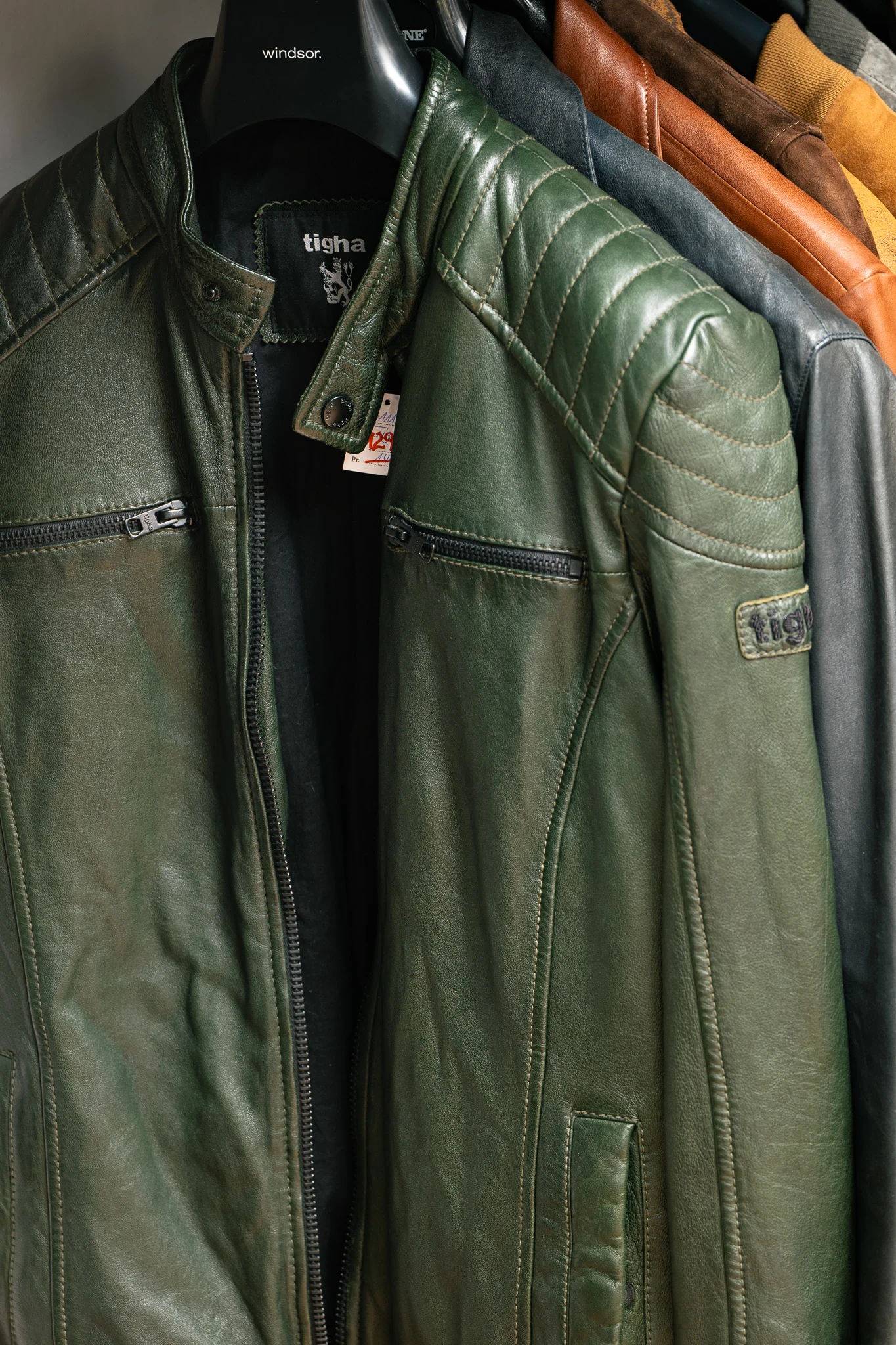 Grüne Lederjacke auf der Kleiderstange im Men Shop